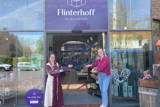 Kerstin und Jenny stehen vor dem Eingang in der Monrestaße. Jenny trägt ein mittelalterliches Kleid.