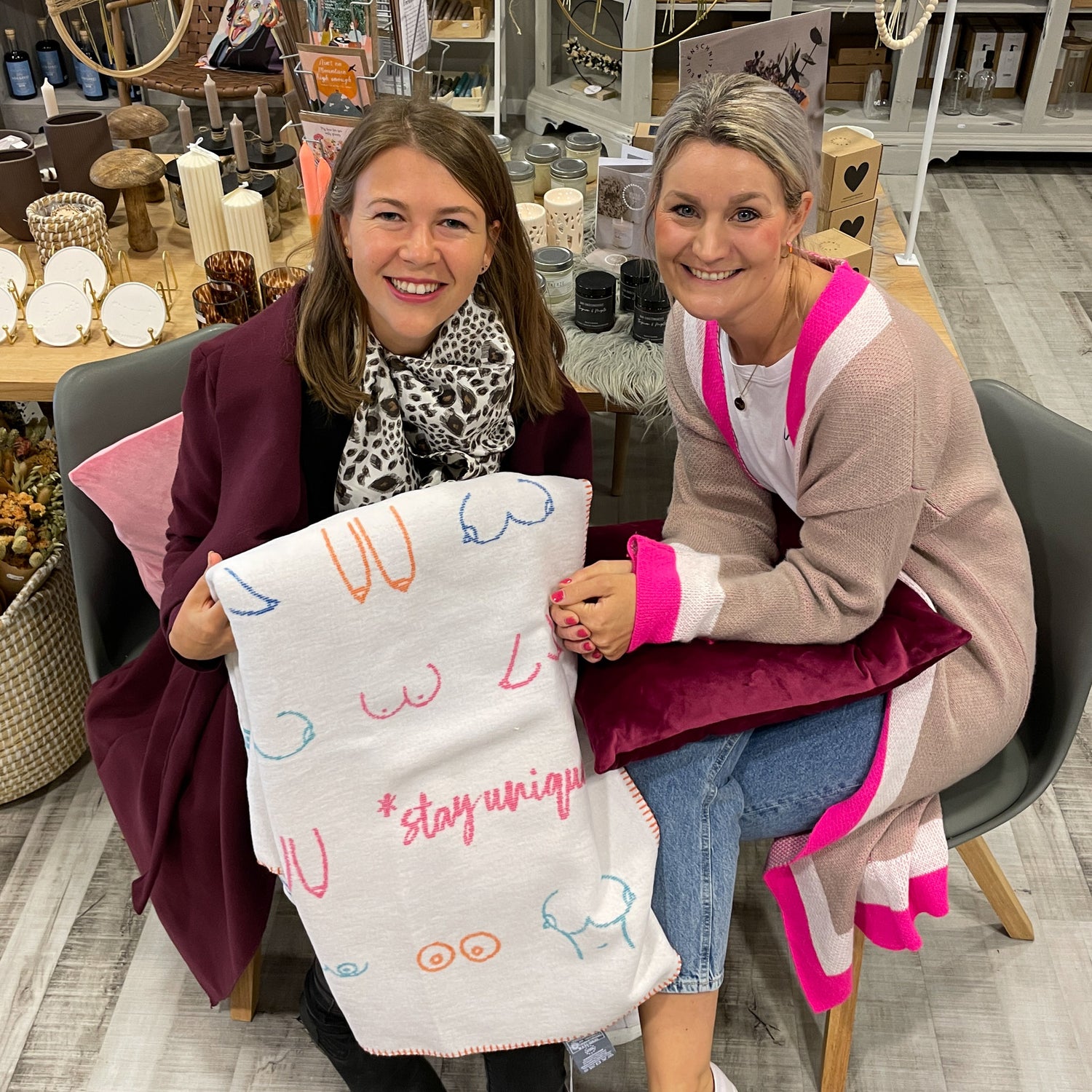 Anika Nobel und Kassandra Fröhlich posieren mit einer Kuscheldecke für die Brustkrebsaktion | Flinterhoff - Für dich und mich