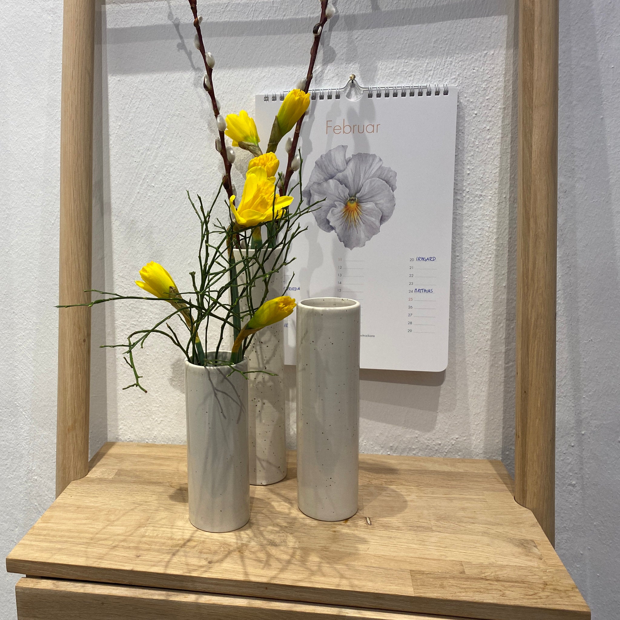 Drei zylindrische Vasen mit Frühlingsblumen