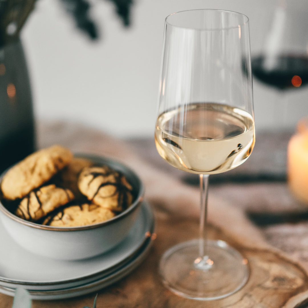 Ein Bild von einem Weinglas mit weißem und rosafarbenem Wein, das Wissen über wahre Weingläser vermittelt.