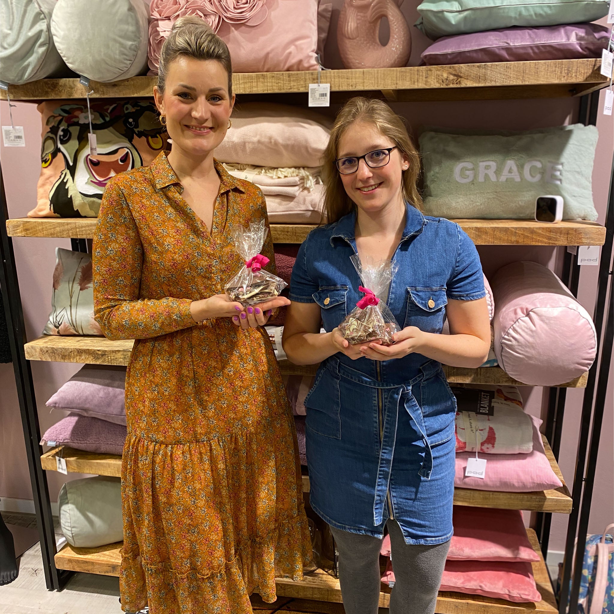 Anika Nobel und Jennifer Kronjäger halten Schokolade für die Brustkrebsspendenaktion in den Händen und lachen in die Kamera | Flinterhoff - Für dich und mich